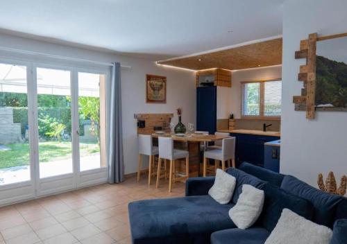 een woonkamer met een blauwe bank en een tafel bij Appartement avec Jardin à 10 min d'Annecy in Charvonnex