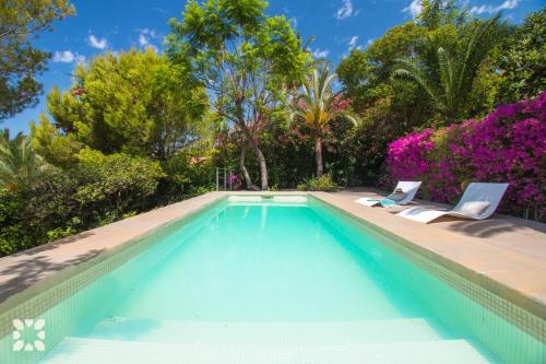 una piscina con due sedie e alberi di Villa Ana Clara by Abahana Villas ad Altea