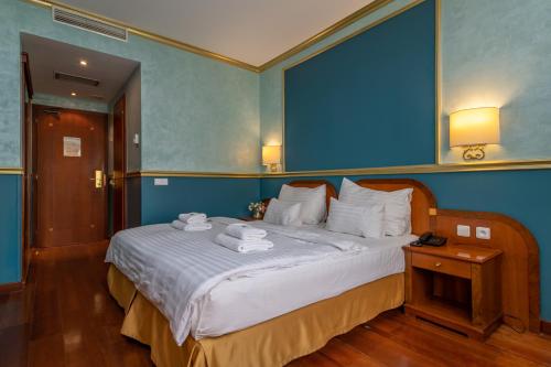 a bedroom with a large bed with towels on it at Hotel Kinsky Fountain in Prague