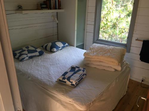 a twin bed in a room with a window at Island Beach House in Värmdö