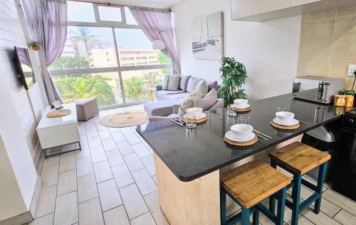 a kitchen and living room with a large window at La Ballito 305 in Ballito