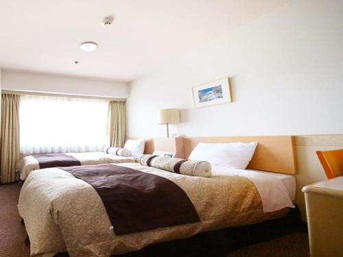 een hotelkamer met 2 bedden en een raam bij The Gotembakan in Gotemba