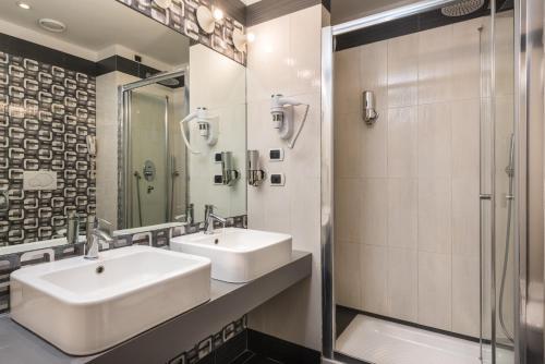 a bathroom with two sinks and a shower at Noba Hotel e Residenze in Rome