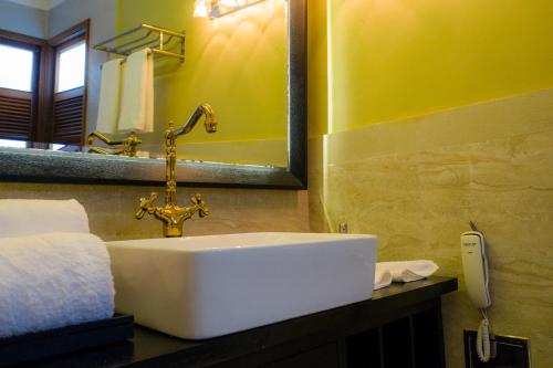 a bathroom with a white sink and a mirror at Fuvahmulah Central Hotel in Fuvahmulah