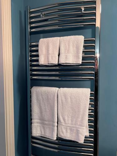a towel rack with white towels in a bathroom at The Townhouse in Miltown Malbay