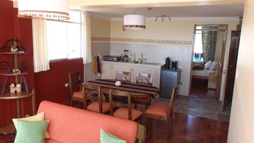 a living room with a table and a kitchen at Apart Happy Cata in Puno