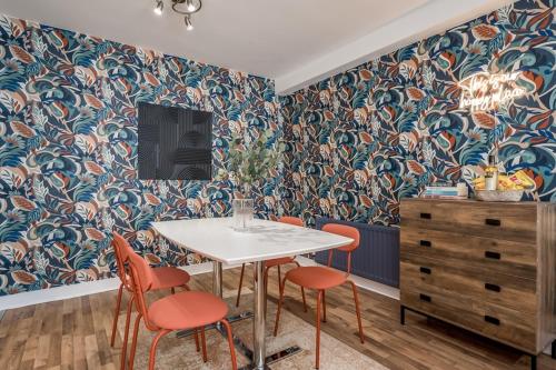 a dining room with a table and orange chairs at Central Belfast Apartments, Victoria Place in Belfast