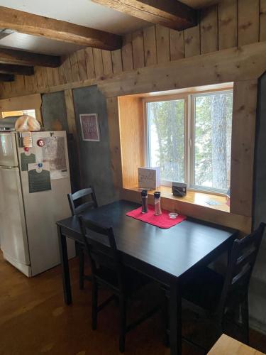 a dining room with a table and a refrigerator at Vines and Puppies Hideaway in Jade City