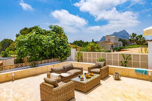 un patio con sofás y una mesa en el balcón en Villa Ancla Blanca by Abahana Villas, en Casas de Torrat
