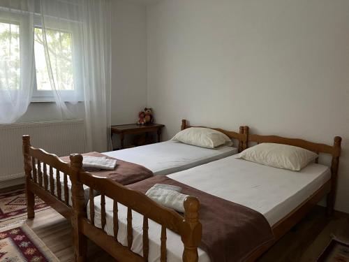 2 camas individuales en un dormitorio con ventana en EMINA, en Mostar