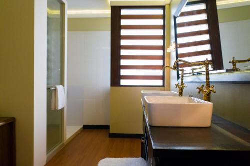 baño con lavabo blanco grande y ventana en Fuvahmulah Central Hotel, en Fuvahmulah