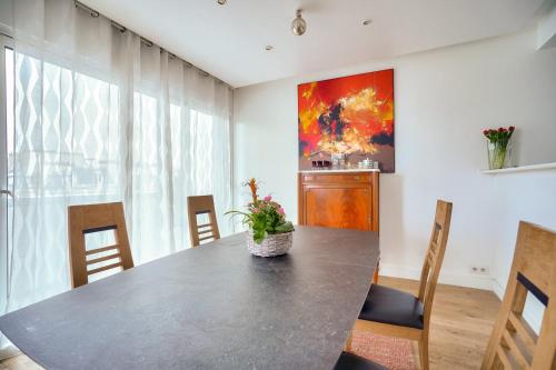 - une table à manger avec une plante en pot dans l'établissement Magnifique appartement 80 m2 face Tour Eiffel, à Paris
