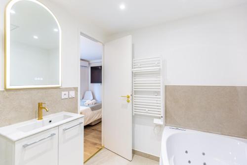 a white bathroom with a sink and a mirror at Lavie Maison Balneo garden flat in Bordeaux