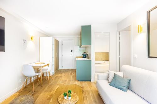 un salon avec un canapé et une table dans l'établissement Lavie Maison Balneo garden flat, à Bordeaux