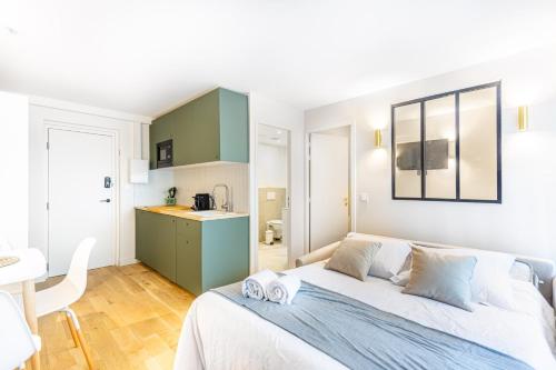 a bedroom with a large bed and a kitchen at Lavie Maison Balneo garden flat in Bordeaux