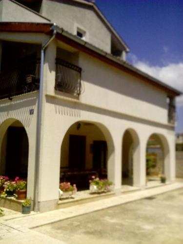 a white building with arches and a balcony at Apartments Zova in Medulin