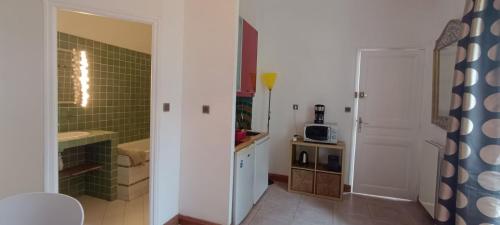 a small kitchen with a sink and a microwave at Le Clos des Galéjades in Porquerolles