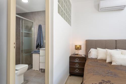 a bedroom with a bed and a bathroom with a toilet at Villa Isabella - Ideal Property Mallorca in Muro