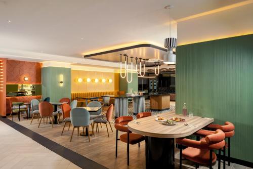 バンコクにあるトライブ リビング バンコク スクンビット 39のテーブルと椅子とバーのあるレストラン