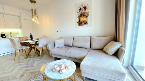 ein Wohnzimmer mit einem Sofa und einem Tisch in der Unterkunft Jantart Resort Słońce Jantaru by TriApart in Jantar