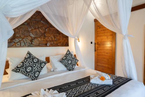 a bedroom with a bed with a canopy at Moonterra Villa Sebatu in Tampaksiring