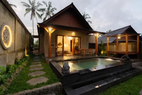 a house with a swimming pool in front of it at Moonterra Villa Sebatu in Tampaksiring