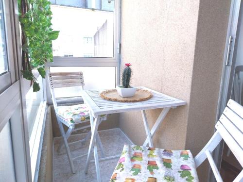 a small table and chair on a balcony with a cactus at Solerma in Viveiro