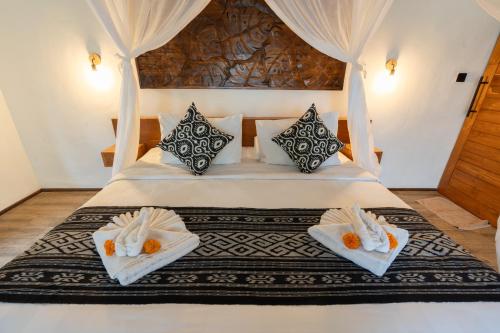 a bedroom with a bed with towels on it at Moonterra Villa Sebatu in Tampaksiring