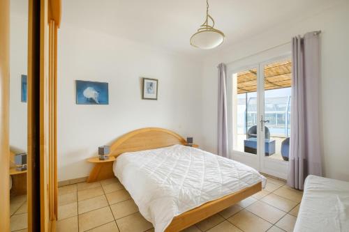 a bedroom with a bed and a glass door at Maison avec Piscine in Tourrettes