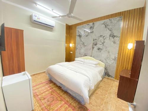 una camera con letto bianco di فندق الرستاق a Ţakham