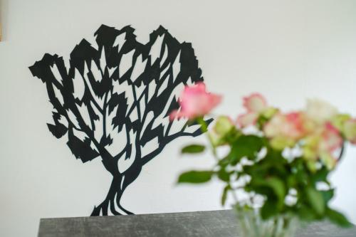 a black and white tree ornament next to a vase of flowers at Maison avec Piscine in Tourrettes