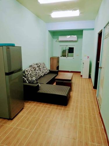 a living room with a black couch and a refrigerator at 蘭嶼小島觀海旅宿 in Lanyu