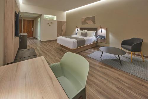 a hotel room with a bed and a table at City Express Plus by Marriott San Luis Potosi in San Luis Potosí
