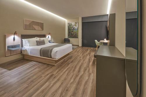 a hotel room with a bed and a desk at City Express Plus by Marriott San Luis Potosi in San Luis Potosí