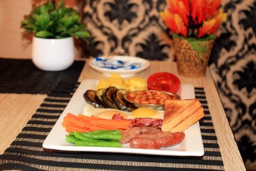 a plate of food with vegetables on a table at Fatmols City Hotel in Ndola