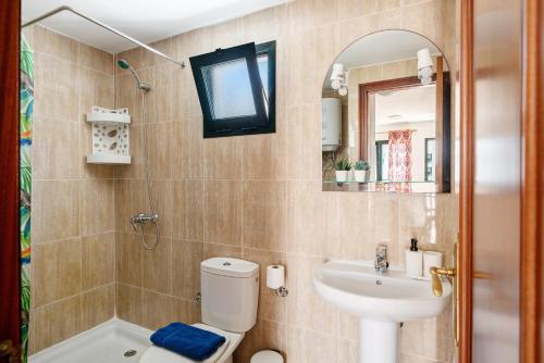 a bathroom with a toilet and a sink and a mirror at Apartamentos Bella Vista in Puerto del Carmen