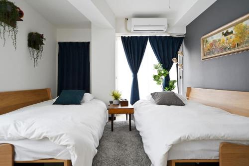 Duas camas num quarto com uma janela em シティマインド京町303 em Osaka