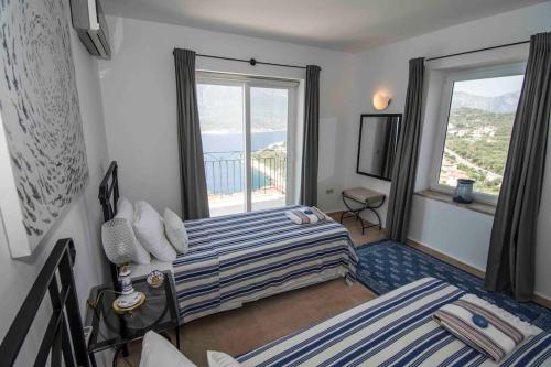 a bedroom with two beds and a large window at Bella Vista, Kaş Antalya in Kaş