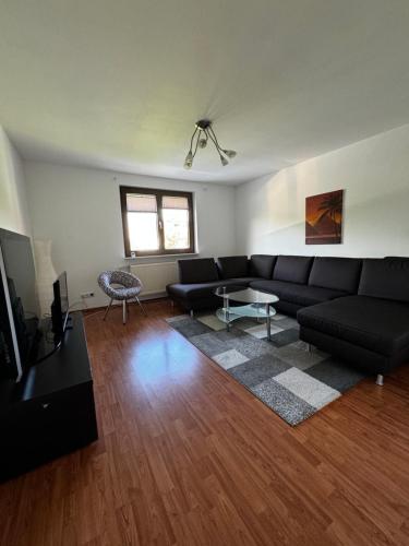 sala de estar con sofá negro y mesa en Apartments Morneweg, en Kronberg im Taunus