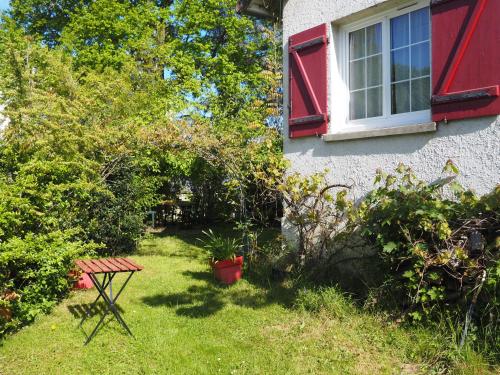 a red window and a picnic table in front of a house at chambre chez l'habitant JO 2024 in Villiers-sur-Orge