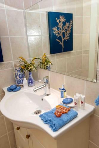 a bathroom sink with a blue towel and a mirror at Bella Vista, Kaş Antalya in Kaş