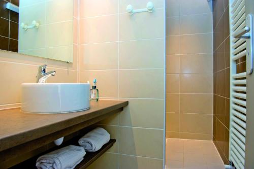 ein Bad mit einem Waschbecken und einer Dusche in der Unterkunft VTF Le Grand Hotel in Montgenèvre