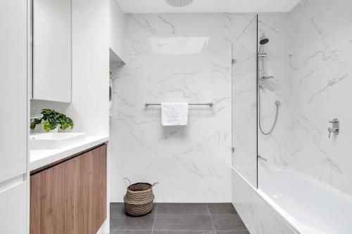 a white bathroom with a shower and a sink at Beautiful Balmain Abode - Balmain, NSW in Sydney