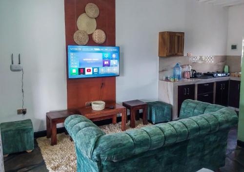 uma sala de estar com um sofá e uma televisão em Sagwe Riviera Diani, Kenya em Diani Beach