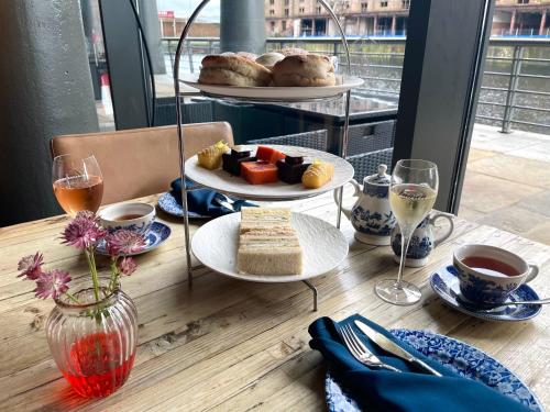 a table with plates of food and glasses of wine at Titanic Hotel Liverpool in Liverpool