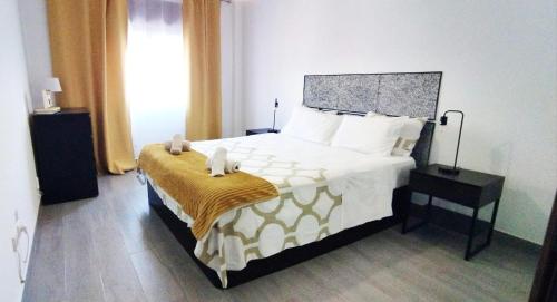 a bedroom with a bed with two stuffed animals on it at A Casa da Nocas in Setúbal