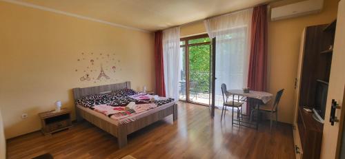 1 dormitorio con cama, mesa y ventana en Bástya Apartmanház, en Sárvár