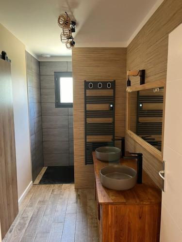 - une salle de bains avec deux lavabos sur un comptoir en bois dans l'établissement Location Jolie Villa située au calme avec piscine à Lacanau océan, à Lacanau