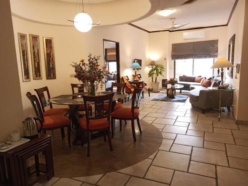 uma sala de estar com mesa e cadeiras em Maisonette Hotels & Resorts em Lahore
