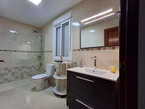 y baño con lavabo, aseo y ducha. en Casa Yerbabuena, en La Puebla de Cazalla